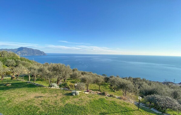 Un paysage côtier offrant une vue sur la mer et les montagnes lointaines.