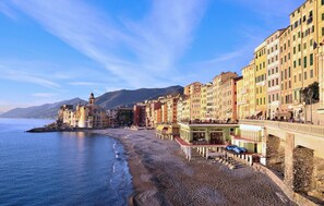 Une ville côtière aux bâtiments aux couleurs vives, dotée d’une plage et d’une église imposante surmontée d’un clocher.