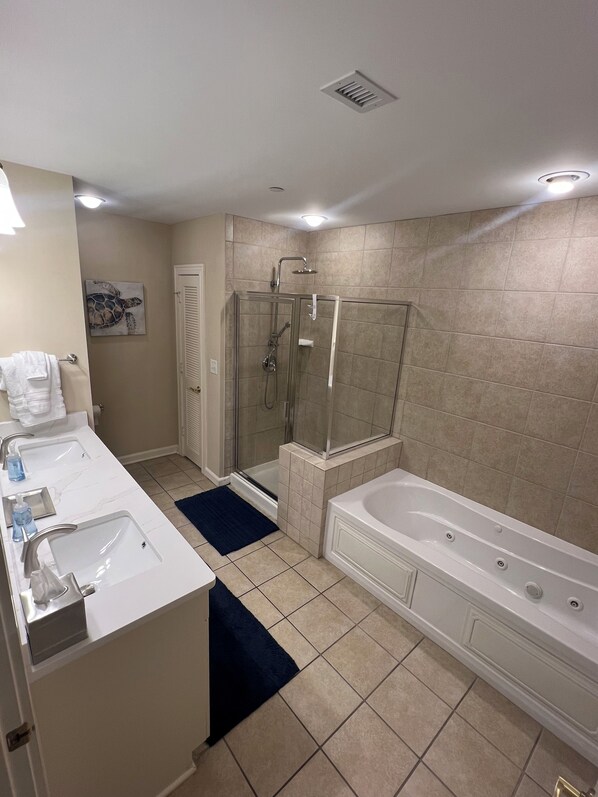 A modern bathroom with a glass-enclosed shower, a large bathtub, and two sinks. - Short walk to pools and the beach! Updated 2bdrm condo! All Hilton pool access! (Myrtle Beach)