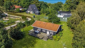 Een huis met een ruime achtertuin, een terras en uitzicht op zee.