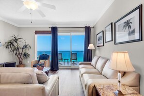 Relax in a spacious room with a seating area, featuring two sofas and a table with a lamp, and enjoy a view of the pool from the balcony.