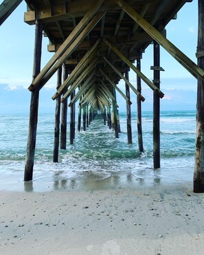 A wooden pier extending into the ocean with a clear view of the water and sky. - Modern oceanfront B Lot, 6 BR, 4.5 baths, Hot Tub, Elevator & Community Pool (North Topsail Beach)