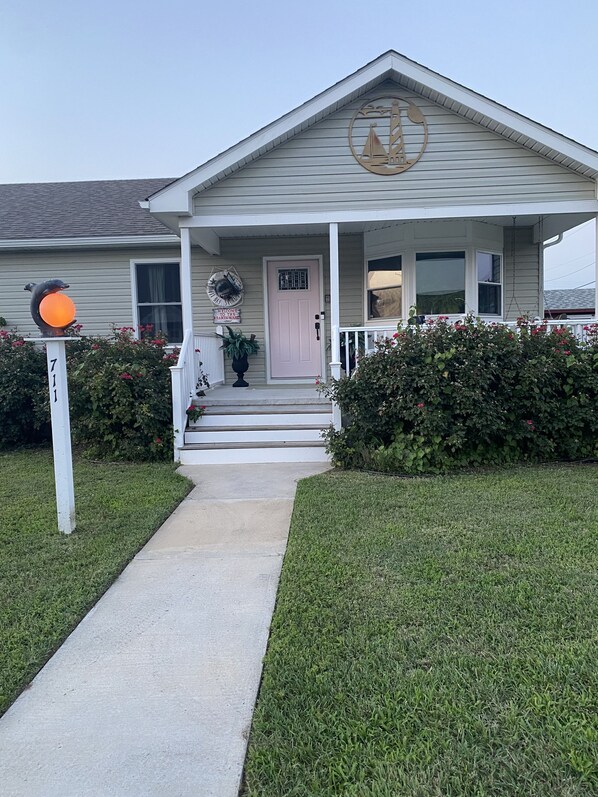 A two-story house with a front porch, a mailbox, and a mailbox number sign. - The Kraken House (Villas)