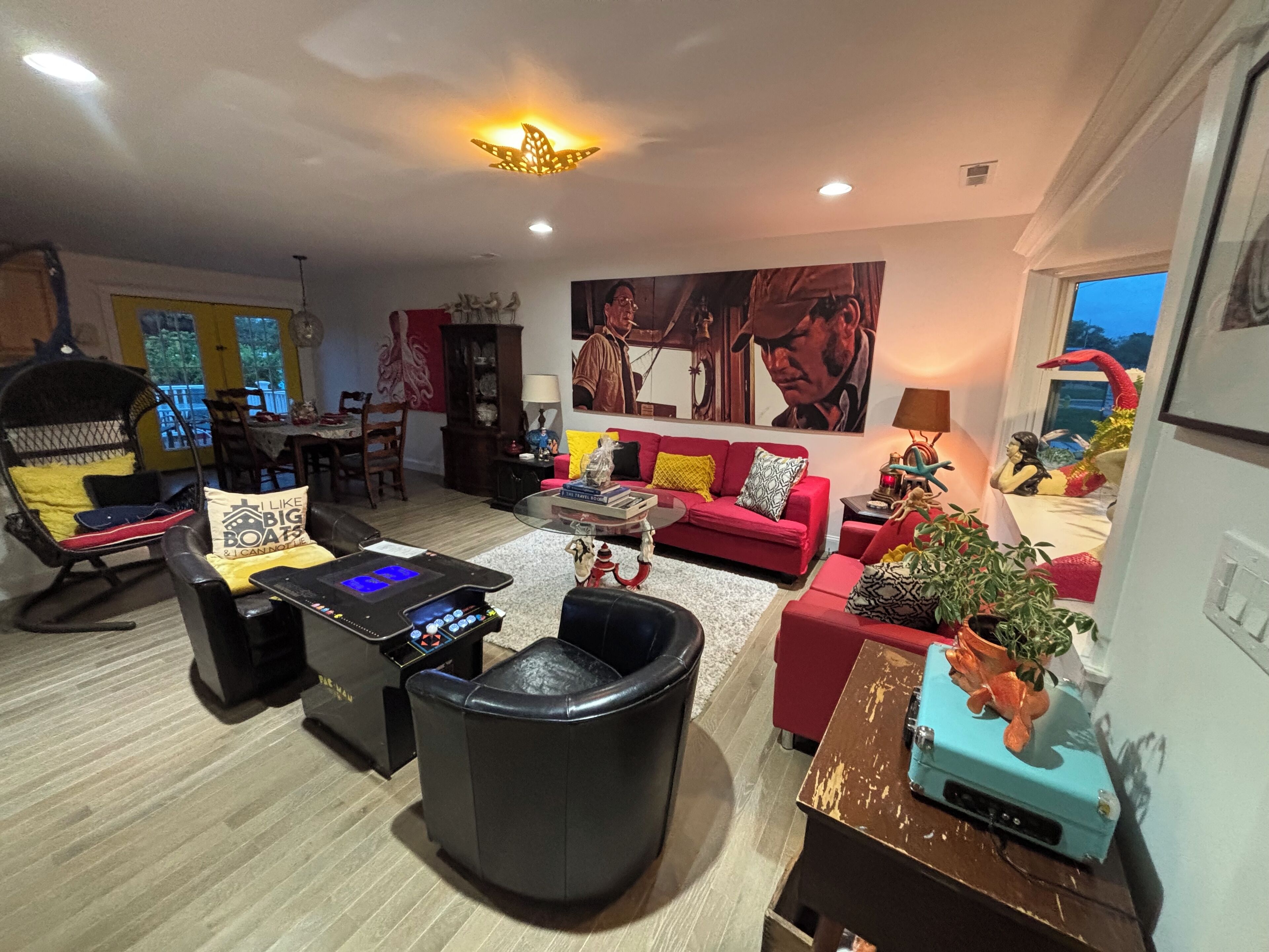 A living room with a red sofa, a black leather chair, a coffee table, and a blue vintage radio.