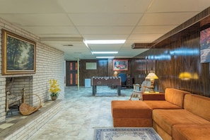 A room with a fireplace, a sofa, a desk with a computer, and a foosball table. - 2 mins to Downtown Burnsville, Restaurants, Shops (Burnsville)