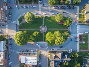 An aerial view of a roundabout with multiple lanes of traffic, surrounded by greenery and buildings. - 2 mins to Downtown Burnsville, Restaurants, Shops (Burnsville)