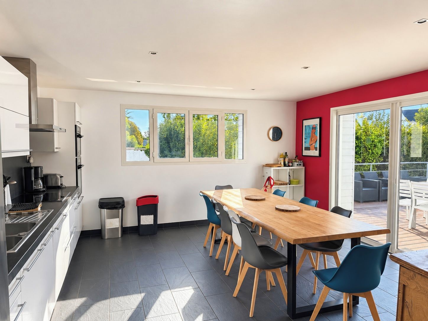 Una cocina moderna con comedor, ventanas amplias y vistas al exterior.