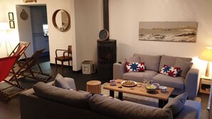 A cozy living room with a sofa, a wooden coffee table, and a fireplace. - Maison Familiale 7ch au Coeur de Ste Marine. Plage à 10m à Pieds ou 5 en Vélos ! (Combrit)