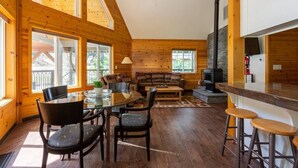 A cozy cabin interior with a dining area, a sofa, and a bar. - Southgate Getaway of Yosemite (Fish Camp)