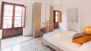 Une chambre à coucher avec un lit, une armoire, un miroir et une porte.