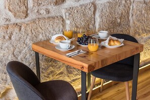 Enjoy a leisurely breakfast at this inviting table, set with a cup, glass, plate, and fresh pastries.