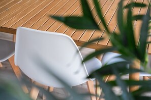 A table and chair sit amidst lush surroundings.