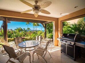 Enjoy al fresco dining in this serene outdoor space, surrounded by lush greenery and a distant mountain view.