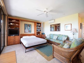 Relax in this serene bedroom with a large bed, wardrobe, and comfortable seating area.