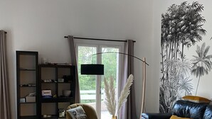 A modern living room with a glass coffee table, leather sofa, and a bookshelf. - Nature in Aix (Venelles)