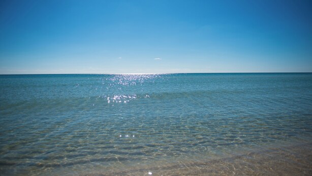 A clear view of the ocean with a calm surface and a bright horizon.