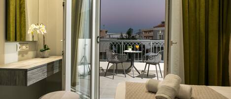 Relax in a spacious room with a large bed, seating area, and balcony.