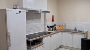 A modern kitchen with white cabinets, a built-in oven, and a countertop with a toaster.