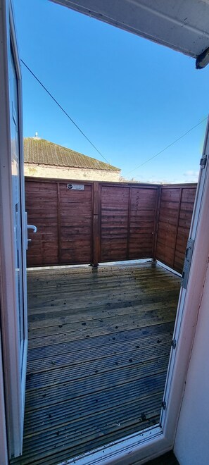 A view through a door into a room with a wooden floor and a wooden wall. - City Express (Plymouth)