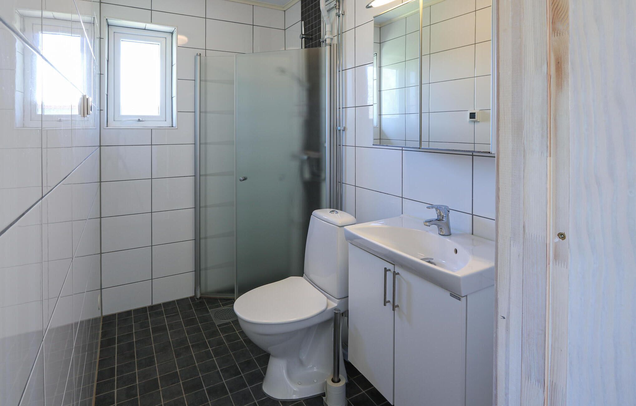 A bathroom with a toilet, sink, and shower.