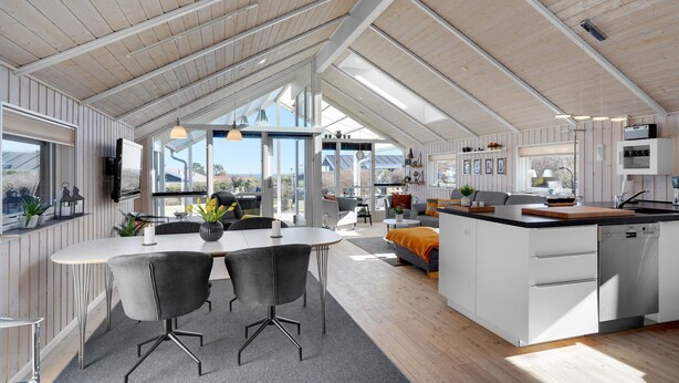 A spacious kitchen with a large island, a dining area with a table and chairs, and a view of the outdoors. - Amazing home in Hadsund with WiFi (Hadsund)