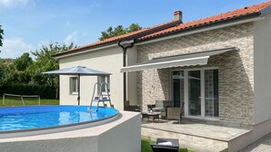 A swimming pool with a ladder, a patio with outdoor furniture, and a stone facade building. - Gorgeous home in Kastav with WiFi (Kastav)