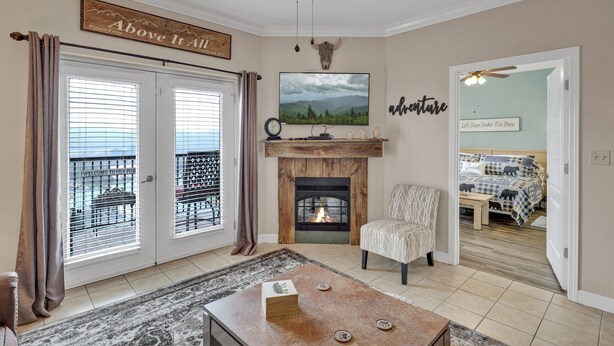 Una sala de estar con chimenea, televisor y balcón con vistas.