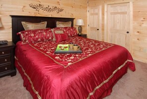 Une chambre avec un grand lit, une tête de lit en bois et une table de chevet avec une lampe.