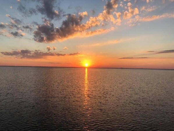 A sunset over a calm sea with a clear horizon. - Beautiful Direct Access Complex,  Coastal Waters Unit 303  (New Smyrna Beach)