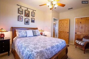Cozy retreat with a large bed, nightstand, and wall-mounted shelf.
