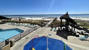 Ein Poolbereich mit Liegestühlen und einer Laube mit Blick auf den Strand.