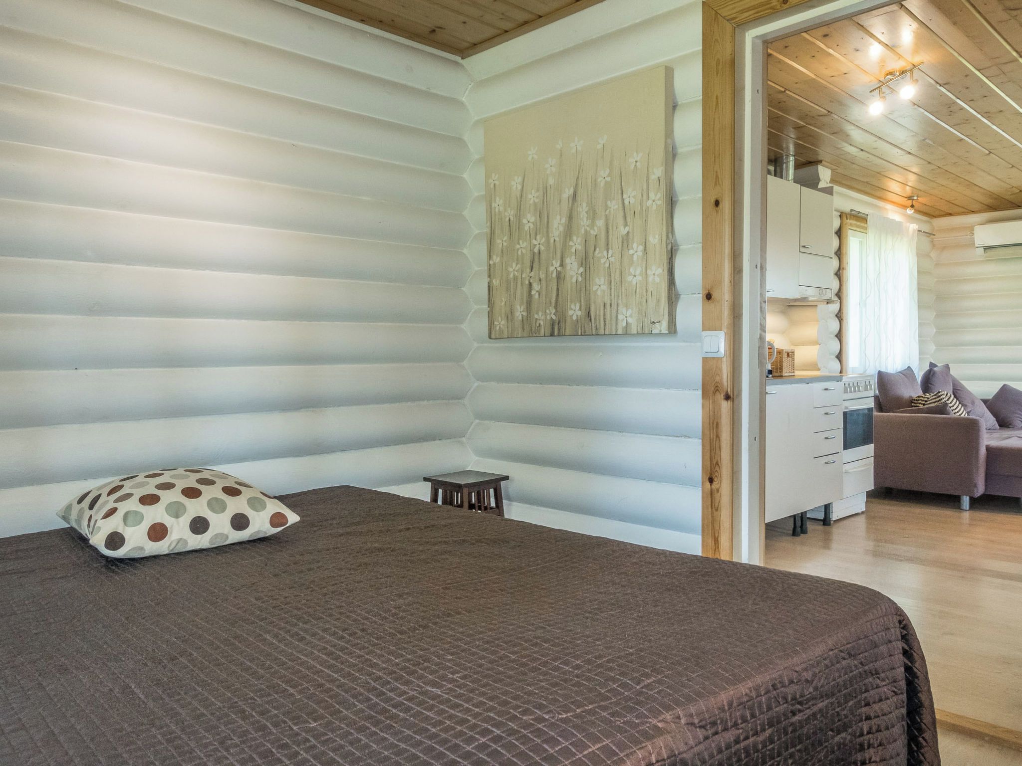 Een kamer met een bed, een tafeltje en een bank.