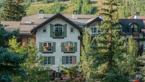 A multi-story building with a central entrance, large windows, and balconies with flower boxes. - Heart of Vail Village - Free Breakfast, Free Parking, No Resort Fee - Walkable (Vail)