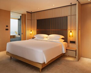Un dormitorio moderno con una cama grande, paneles de madera y dos lámparas fijadas a la pared.