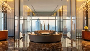 A modern lobby with a circular seating area, large windows, and a city view.