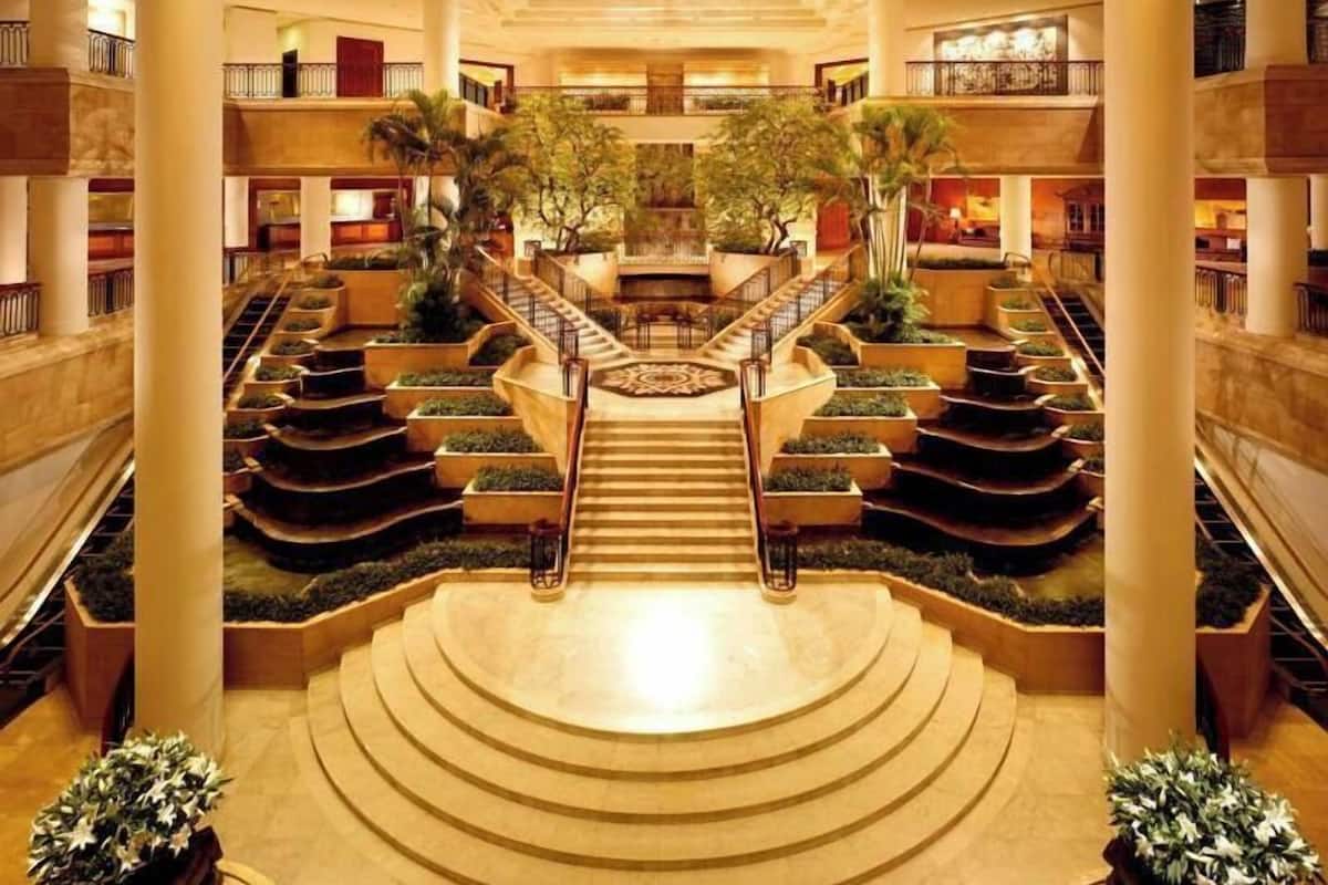 Un atrio de varios niveles con una escalera central, varios pisos y plantas de interior.