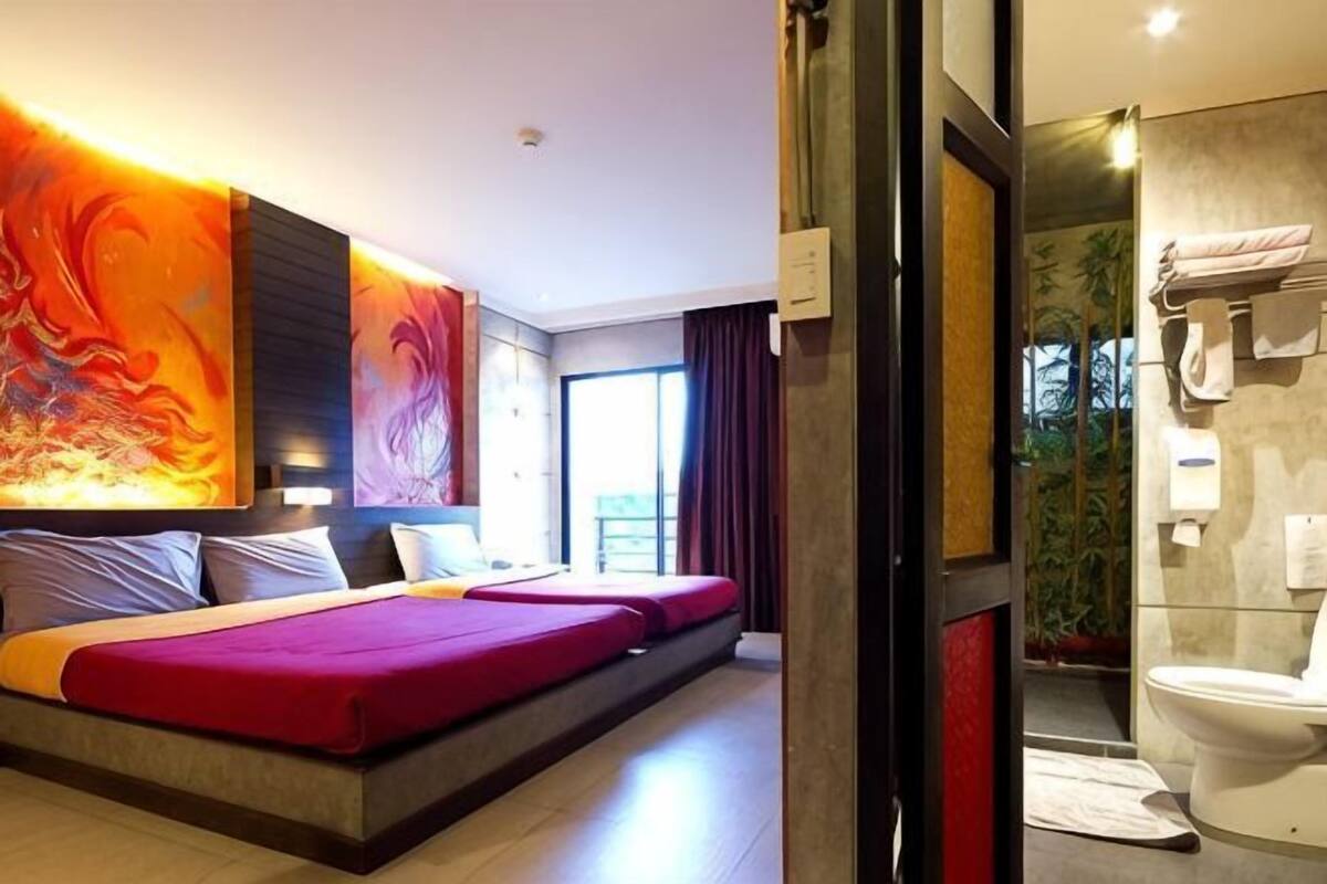 Een moderne hotelkamer met een groot bed, een douchegedeelte en uitzicht op de omgeving.