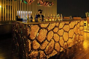 A bar area with a stone-textured counter and a neon sign above. - Pak Ping Ing Tang Boutique Hotel (Nonthaburi)