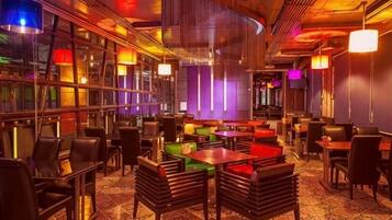 A restaurant with multiple seating areas, including tables and booths, and a bar area with a counter.