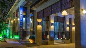 A modern building with a well-lit entrance, large windows, and a staircase leading to the main area. - Pak Ping Ing Tang Boutique Hotel (Nonthaburi)