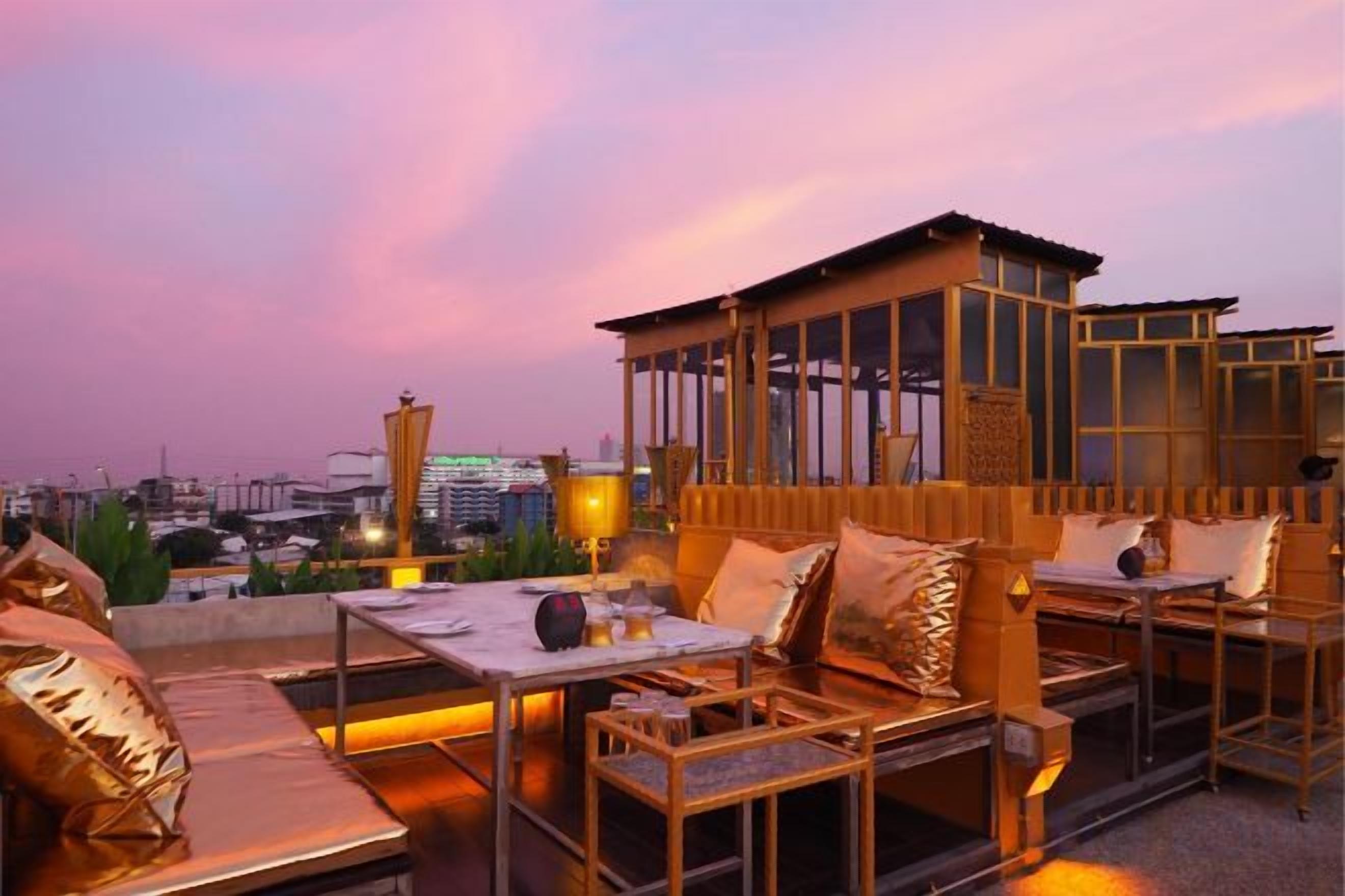 A rooftop terrace with outdoor seating and a view of the city skyline.
