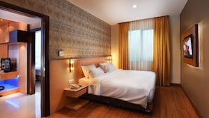 A hotel room with a bed, bedside table, and a television.
