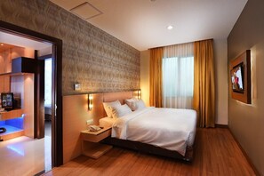 A hotel room with a bed, bedside table, and a television.