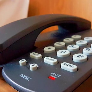 A black telephone with buttons labeled 'MUTE,' 'FLASH,' 'REDIAL,' and 'IN USE.' - Orange Business Hotel Petaling Jaya (Petaling Jaya)