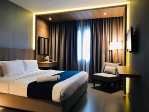 A modern hotel room with a large bed, a desk, a chair, a TV, and a window with curtains. - Orange Business Hotel Petaling Jaya (Petaling Jaya)