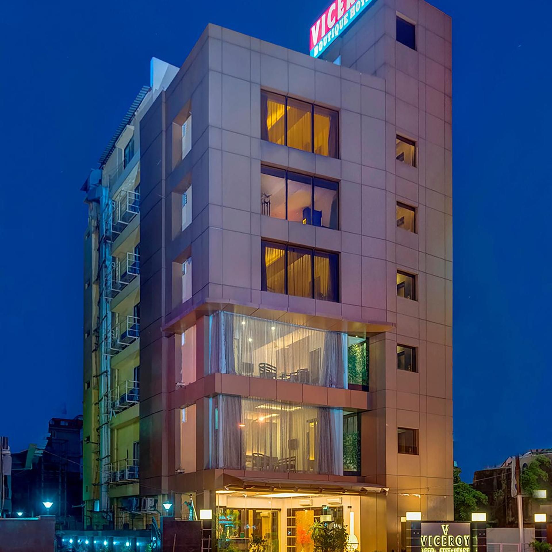 A multi-story hotel with a visible entrance, balconies, and a sign indicating it is a boutique hotel.