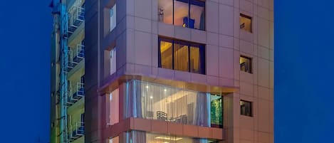 A multi-story hotel with a visible entrance, balconies, and a sign indicating it is a boutique hotel.