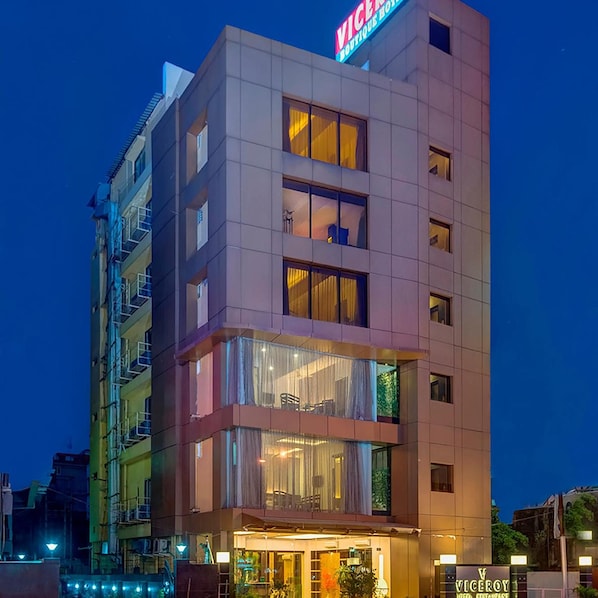 A multi-story hotel with a visible entrance, balconies, and a sign indicating it is a boutique hotel.