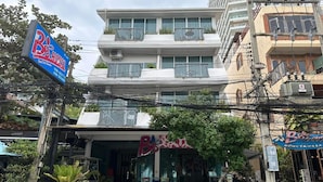 A multi-story building with balconies, a storefront with a sign, and outdoor seating. - Bbhouse Pattaya (Pattaya)