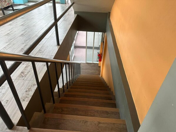 A staircase with wooden steps and black metal railings, leading to a lower level. - Bbhouse Pattaya (Pattaya)